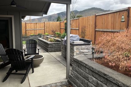 stacked stone retaining walls with planting beds and built-in barbecue